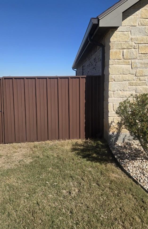 Residential metal privacy fence with clean steel posts in Texas
