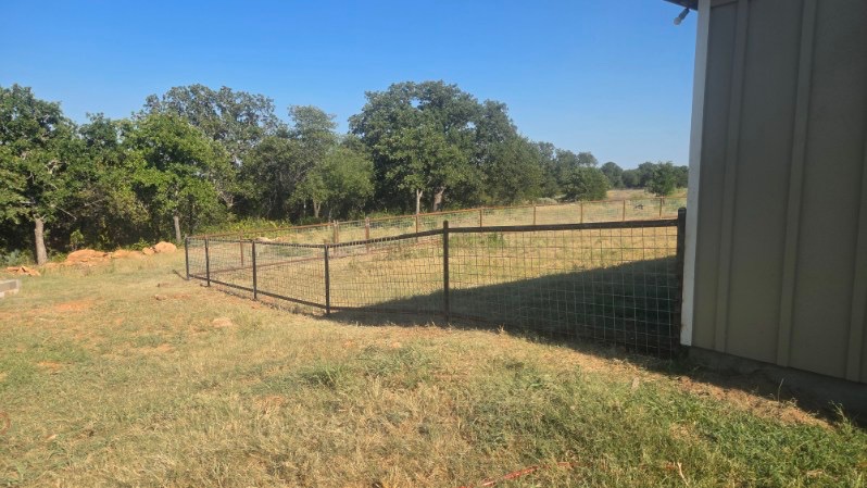 Pipe and 4x4 wire-panel fence enclosing a Texas acreage home