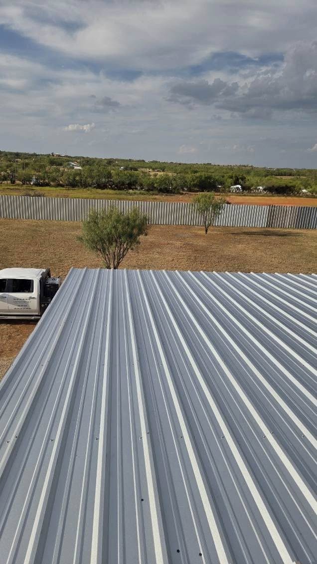Aerial view of a new metal roof and work truck on a Texas job site