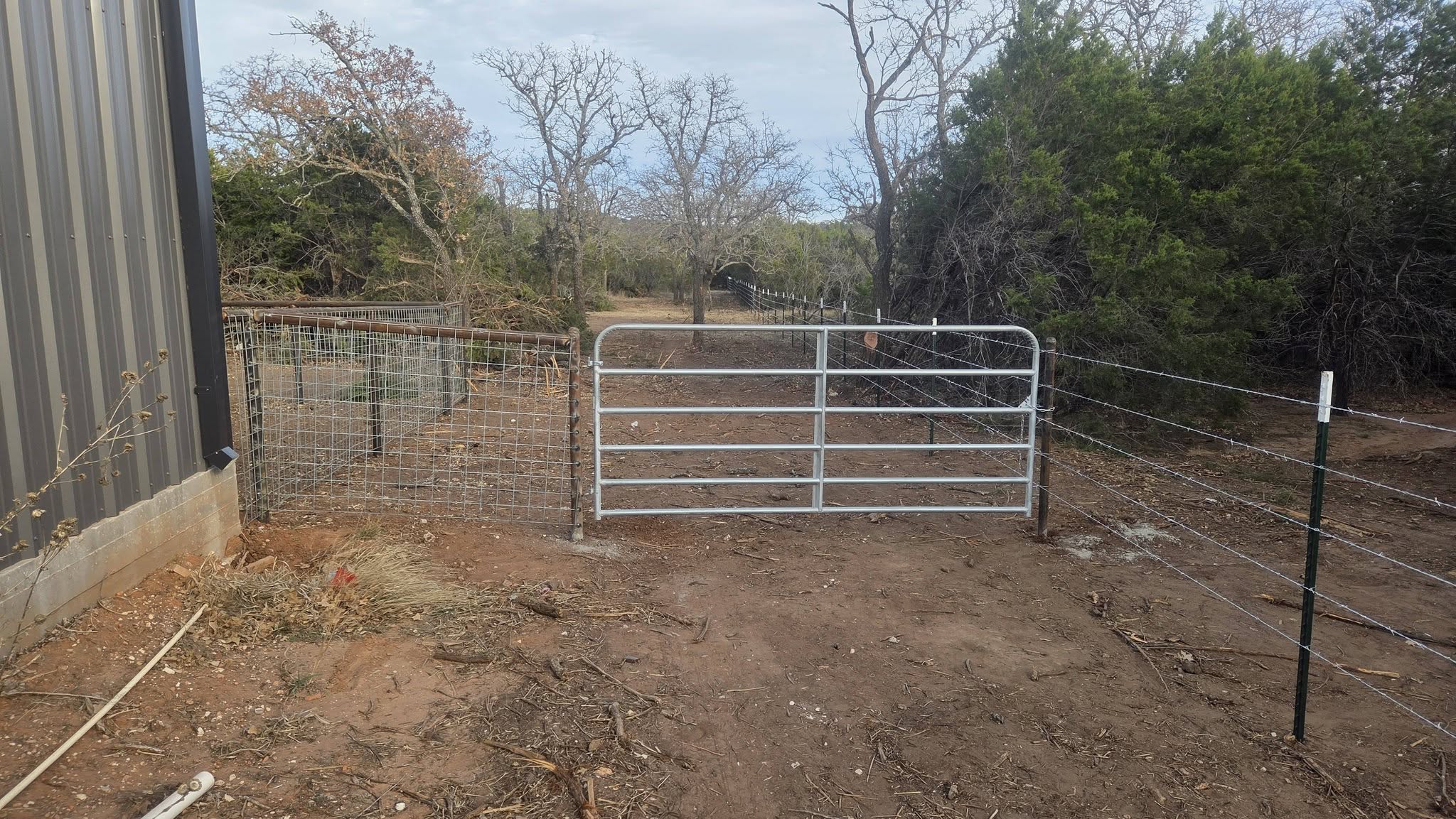 Ranch entrance gate with cattle fencing built by Lonestar Fencing & Welding in Texas