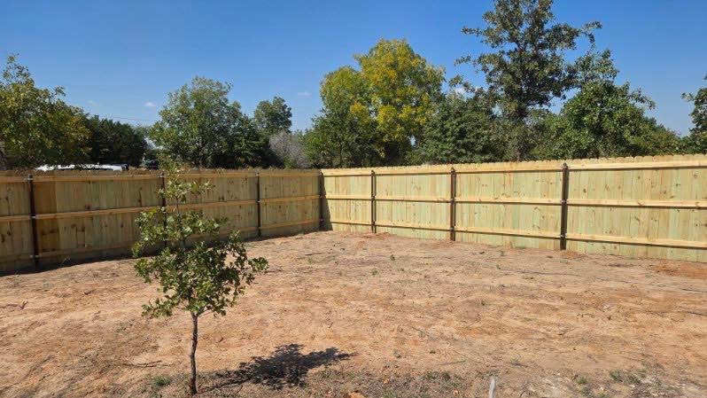 Panoramic view of a wood privacy fence enclosing a residential backyard in Texas