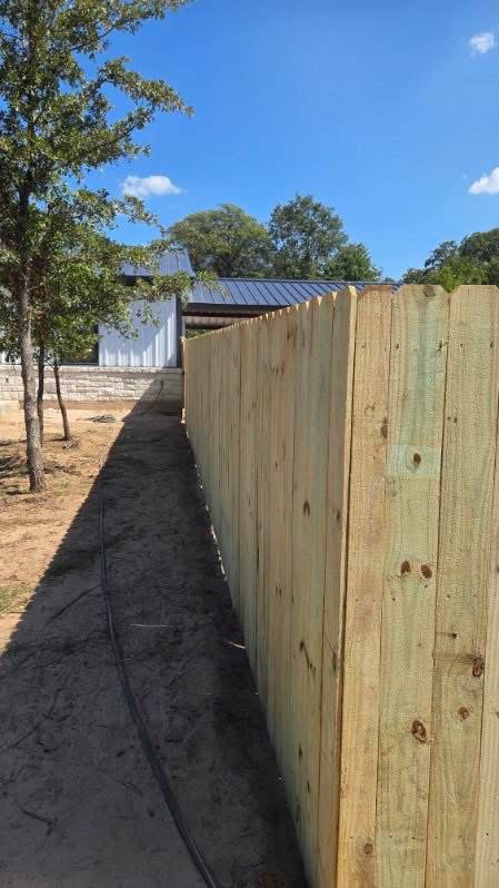 Close view of straight cedar pickets on a finished residential privacy fence in Texas