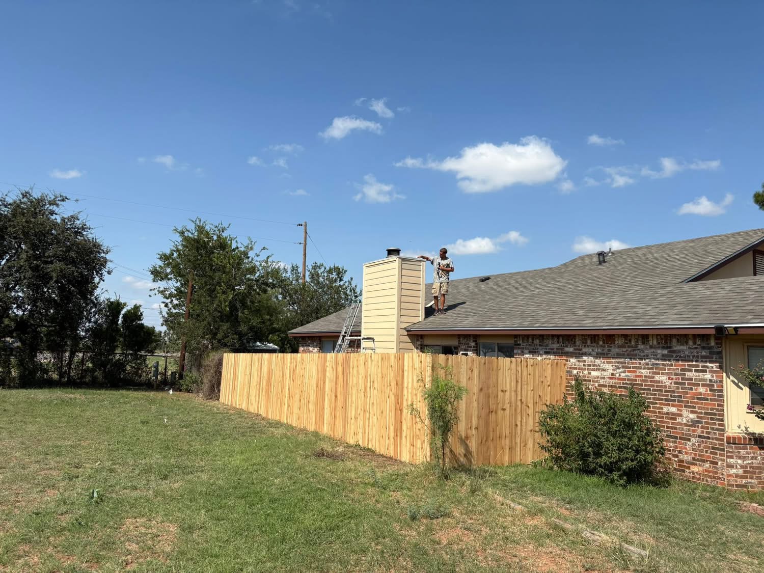 New cedar privacy fence enclosing a backyard beside a Texas home