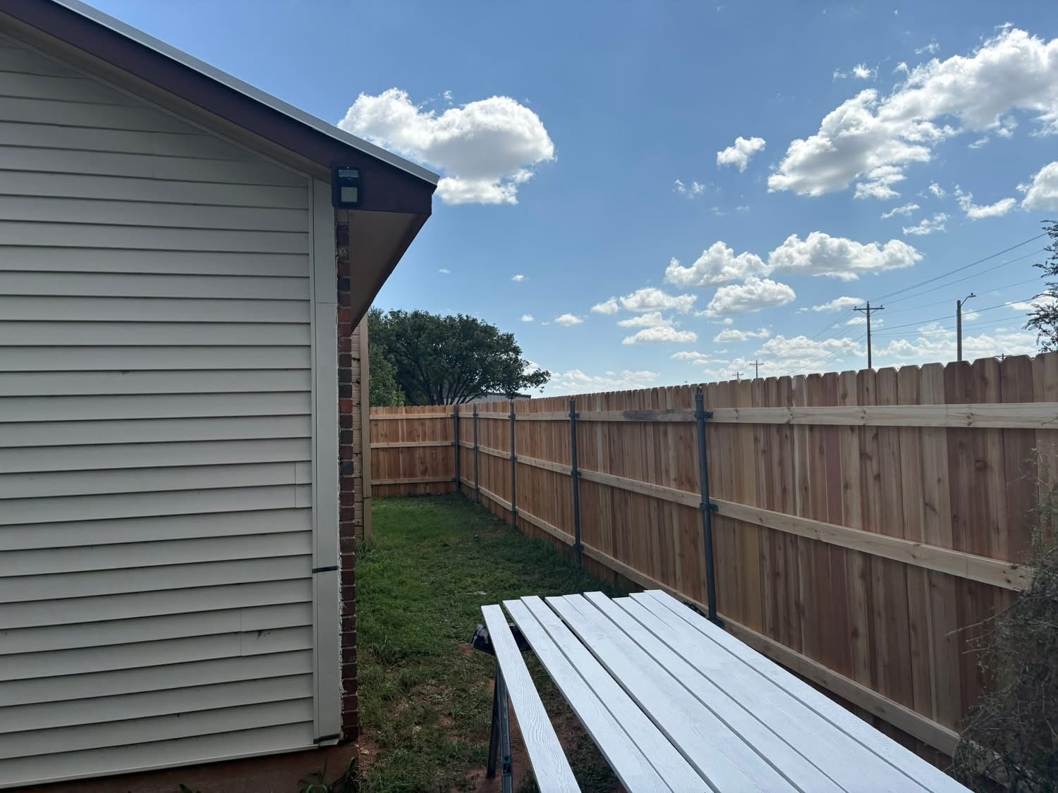 Back side of a cedar privacy fence built with welded steel posts and wood rails in Texas