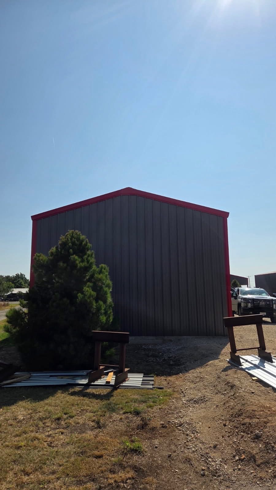 Finished charcoal metal workshop with red trim built by Lonestar Fencing & Welding in Texas