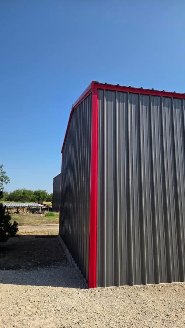Metal wall panels and red trim on a finished Texas workshop building