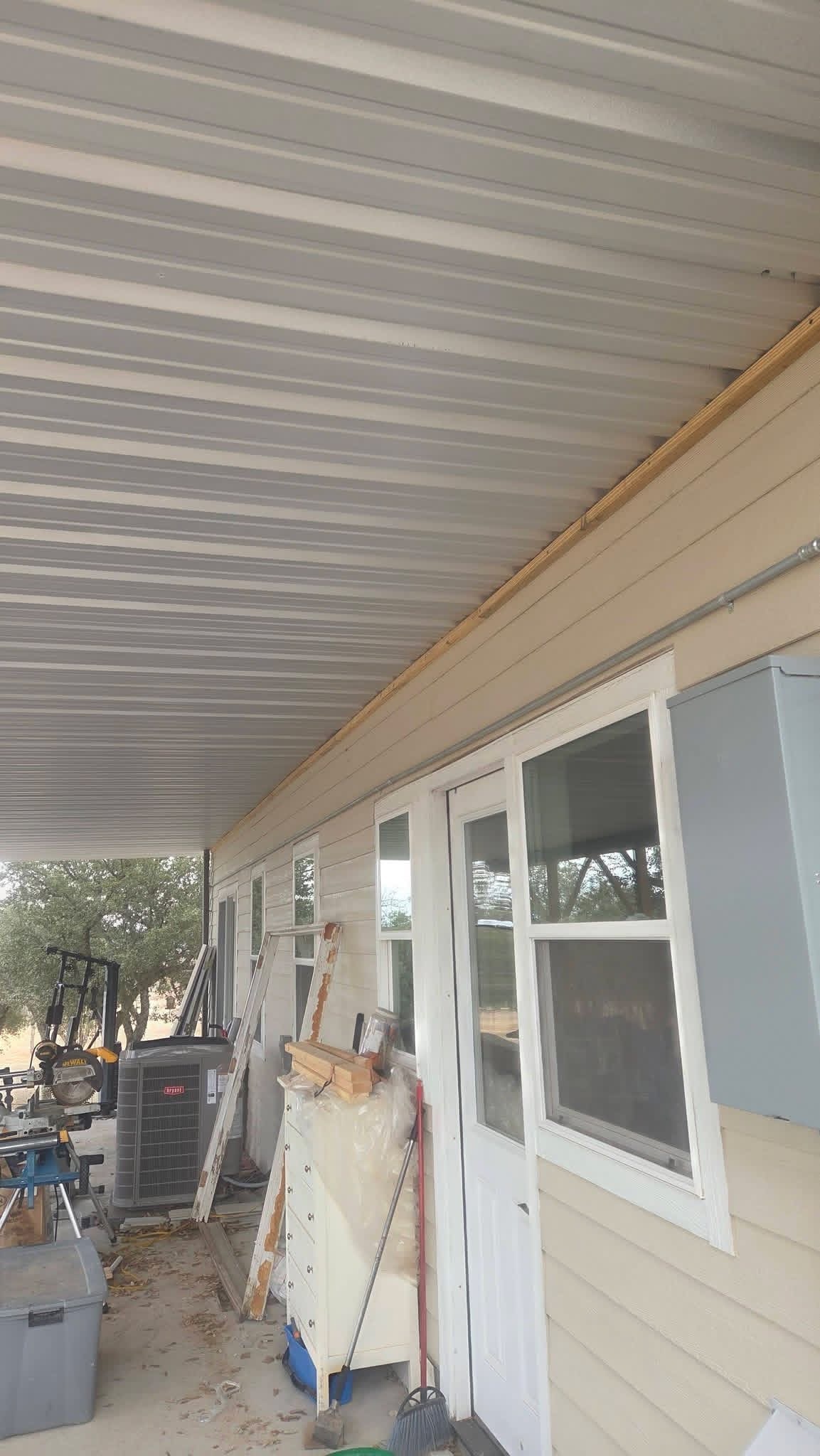 Metal-panel ceiling beneath a custom covered patio and carport in Texas