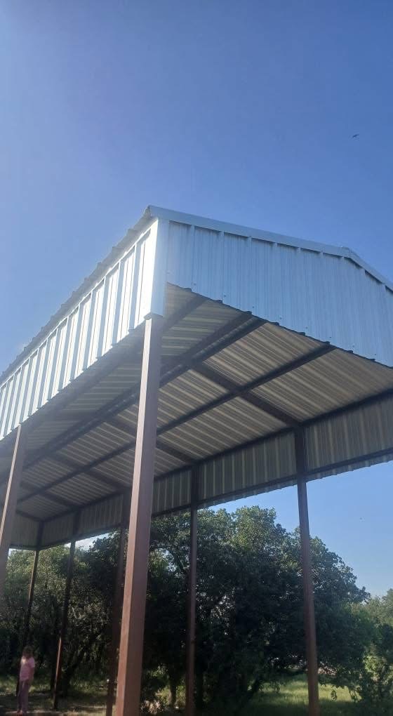 Side view of a tall steel RV cover with metal roofing and enclosed gable trim