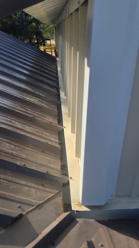 Close view of weather-tight roof flashing where two metal building sections meet