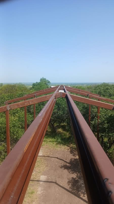 Welded roof framing for a long-span metal RV cover on a Texas property
