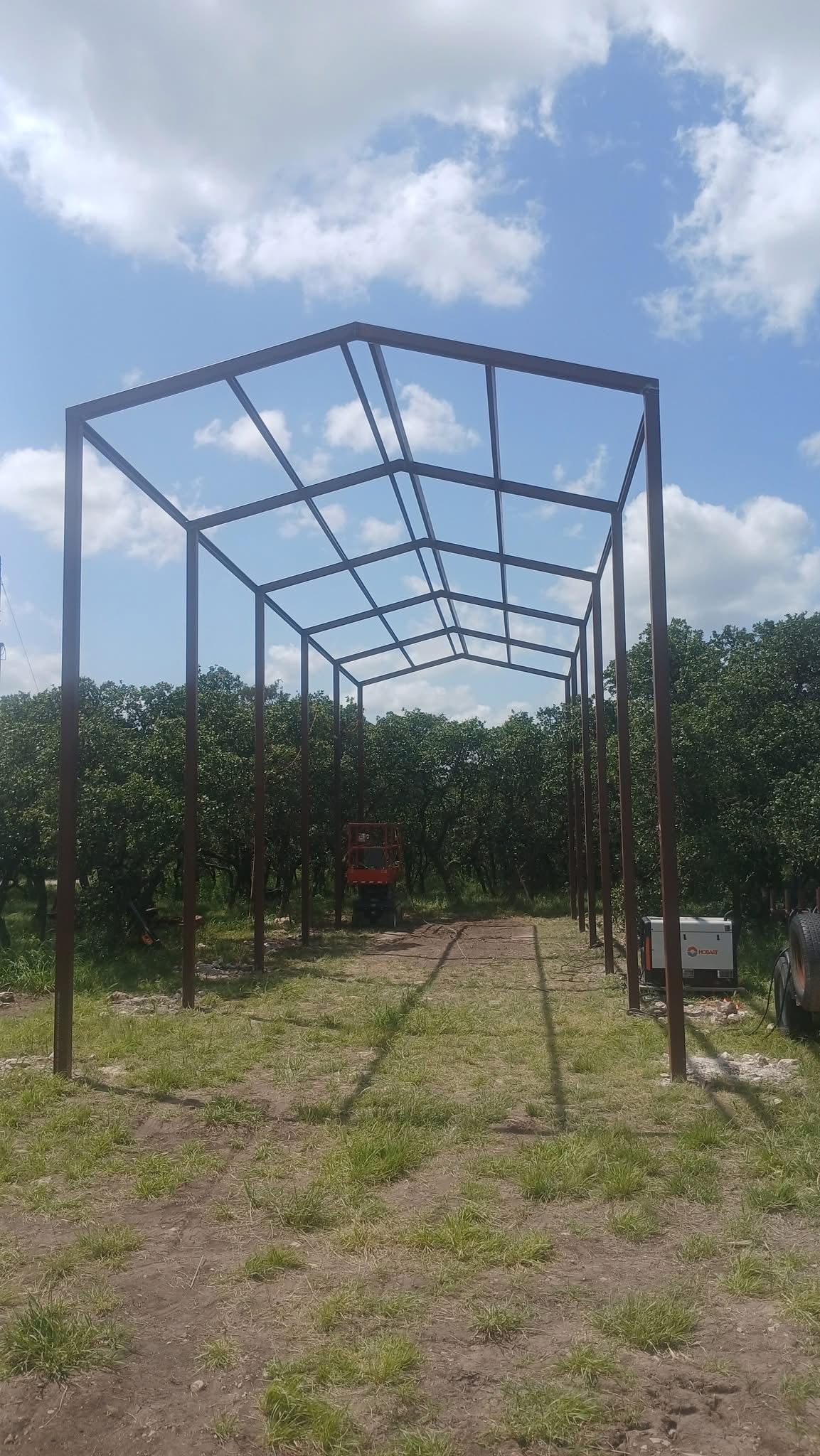 Tall welded steel frame under construction for a custom RV cover in Texas