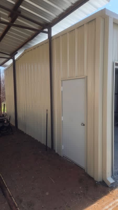 Walk-through entry door and tan wall panels on a custom metal garage in Texas