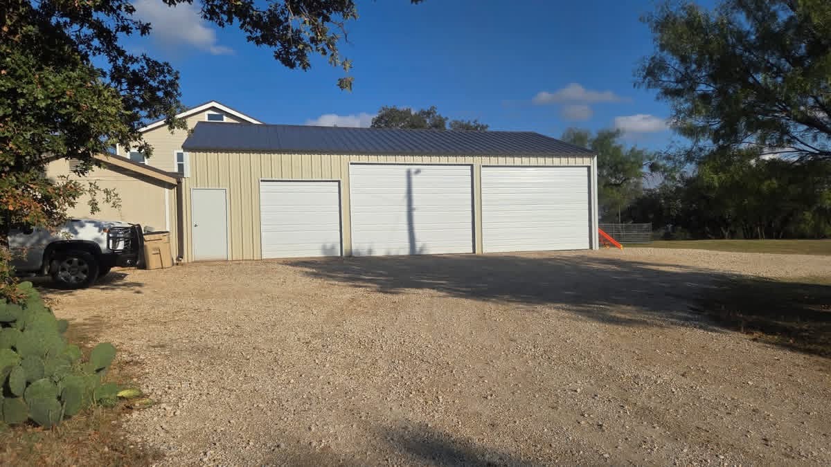Front view of a three-bay metal garage built by Lonestar Fencing & Welding in Texas