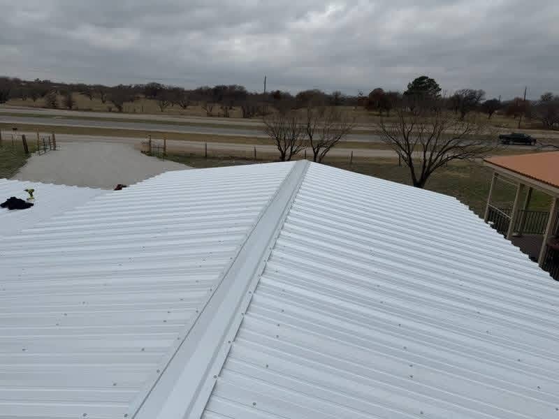 White metal roof panels installed on a custom Texas shop building