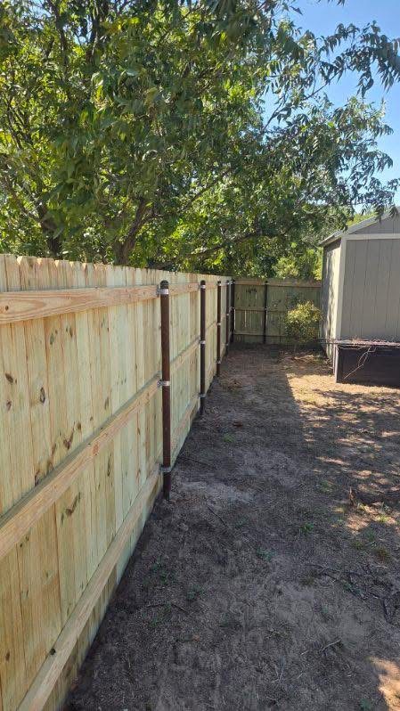 Cedar privacy fence with durable steel posts installed beside a backyard shed in Texas