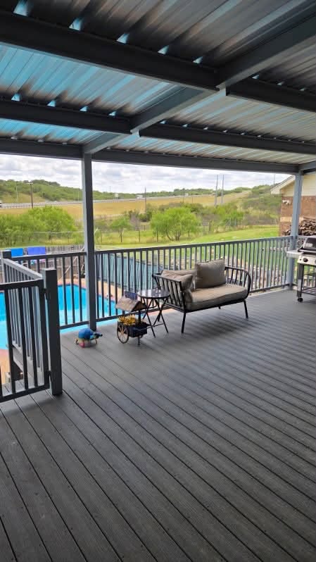 Covered metal deck with steel framing, railings, and outdoor seating
