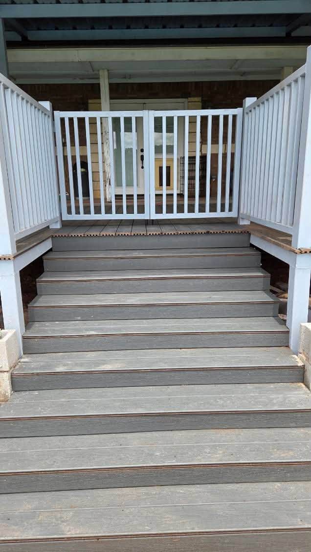 Finished deck stairs with metal railings and a matching safety gate