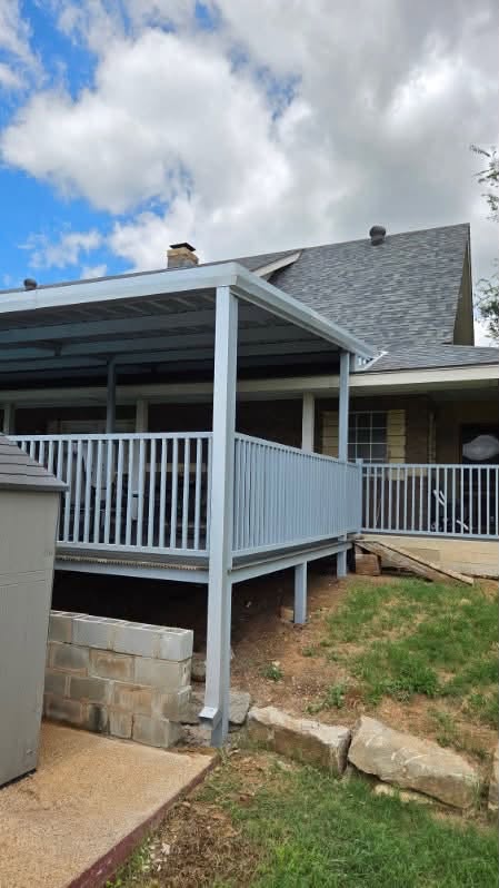 Exterior corner of a metal-framed deck with a covered patio roof and railings