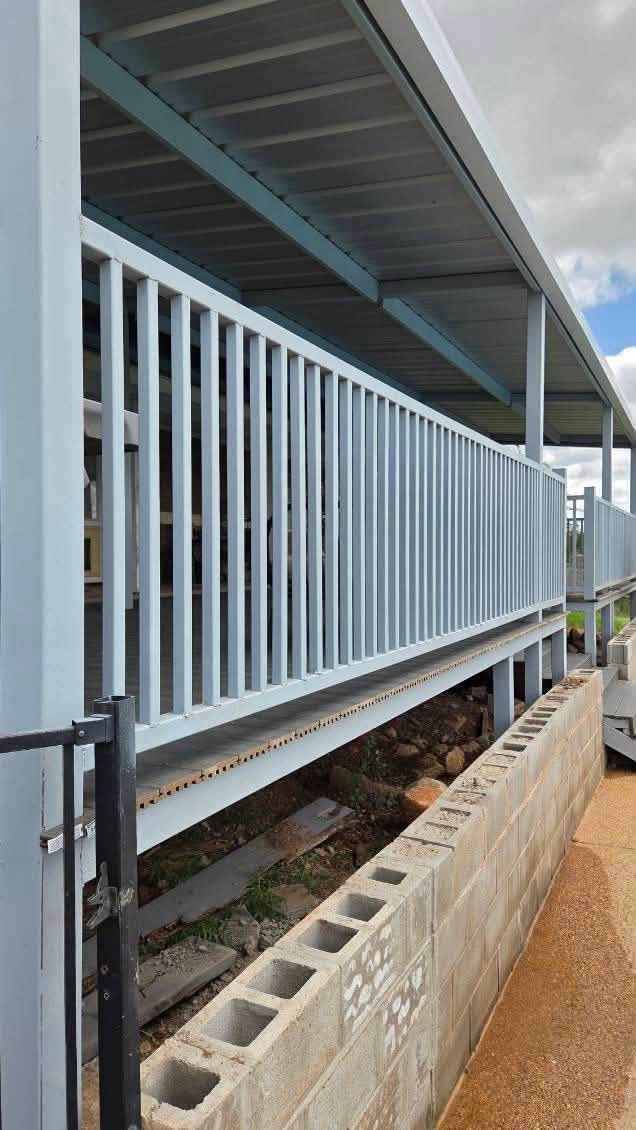 Close view of welded metal deck railings, framing, and covered roof structure